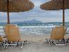 Bastschirme und Sonnenliegen am Sandstrand